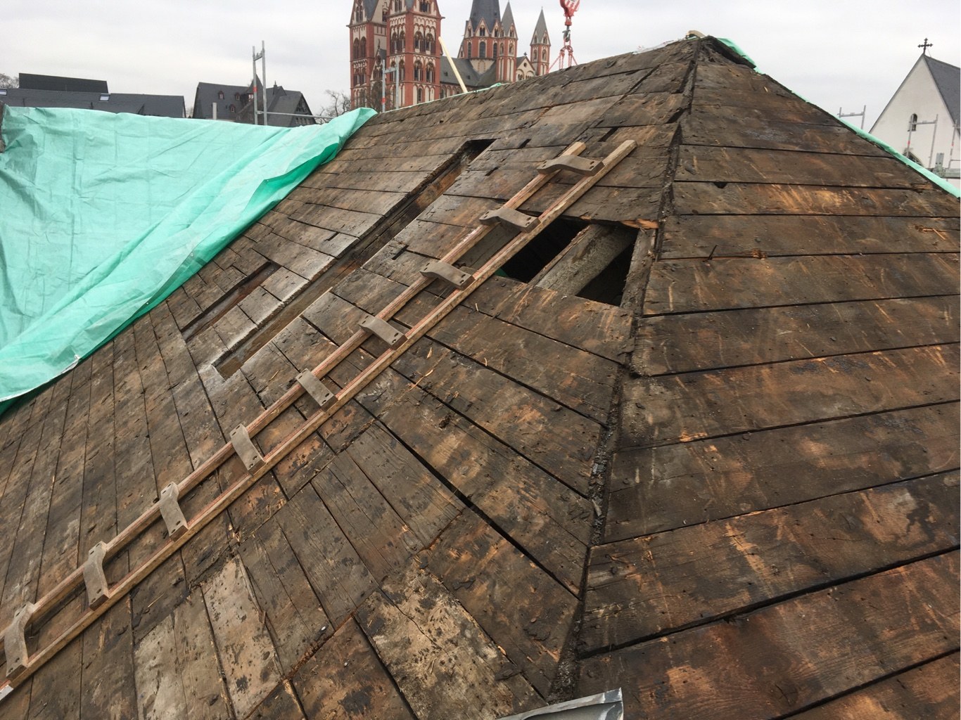 Abgedeckter historischer Dachstuhl des Dom Hotels mit dem Limburger Dom im Hintergrund