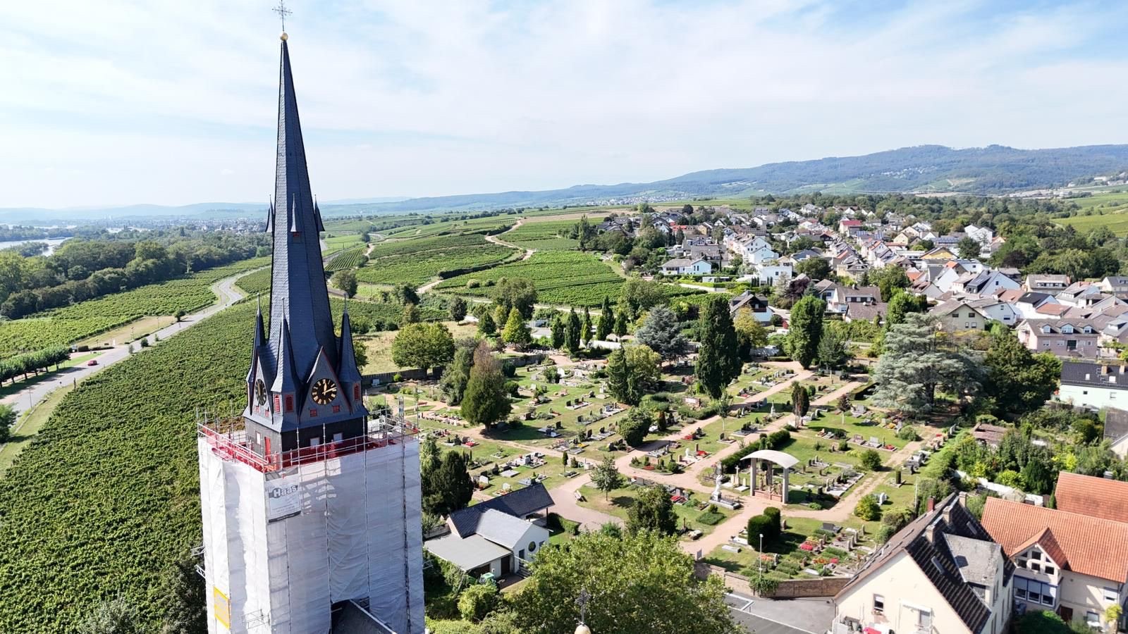 Luftaufnahme der fertigen Turmspitze von St. Markus Erbach, unten das eingerüstete Kirchenschiff
