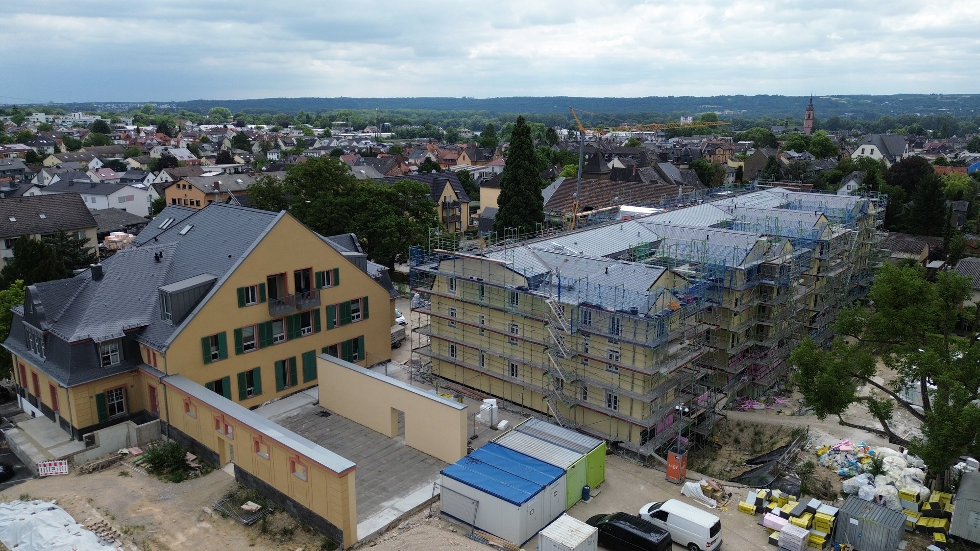 Luftaufnahme vom Alten Staatsweingut in Eltville: saniertes Schieferdach am Altbau, daneben die laufende Baustelle